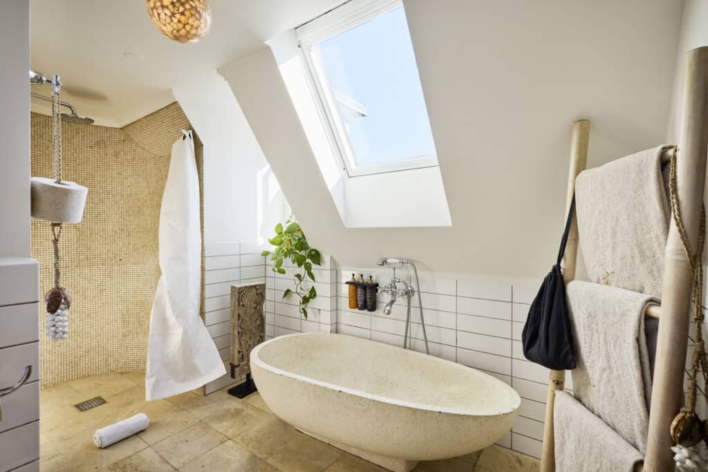 Penthouse bathroom with bright lighting and bathtub at Axel Guldsmeden Hotel in Copenhagen