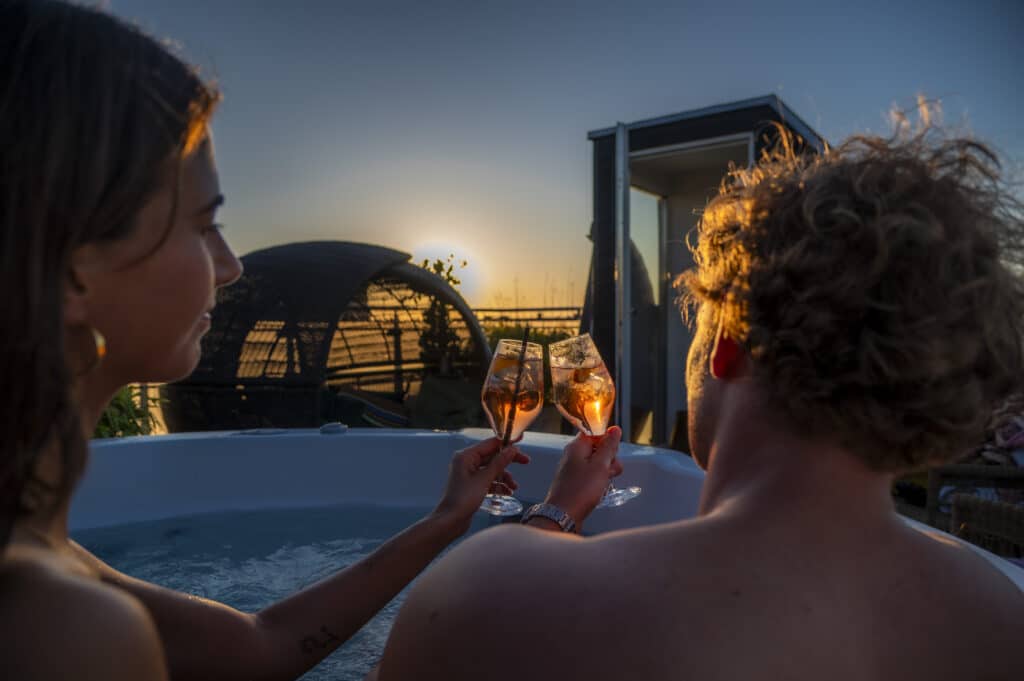 Couple in hot tub at Axel Guldsmeden Hotel rooftop during sunset in Copenhagen